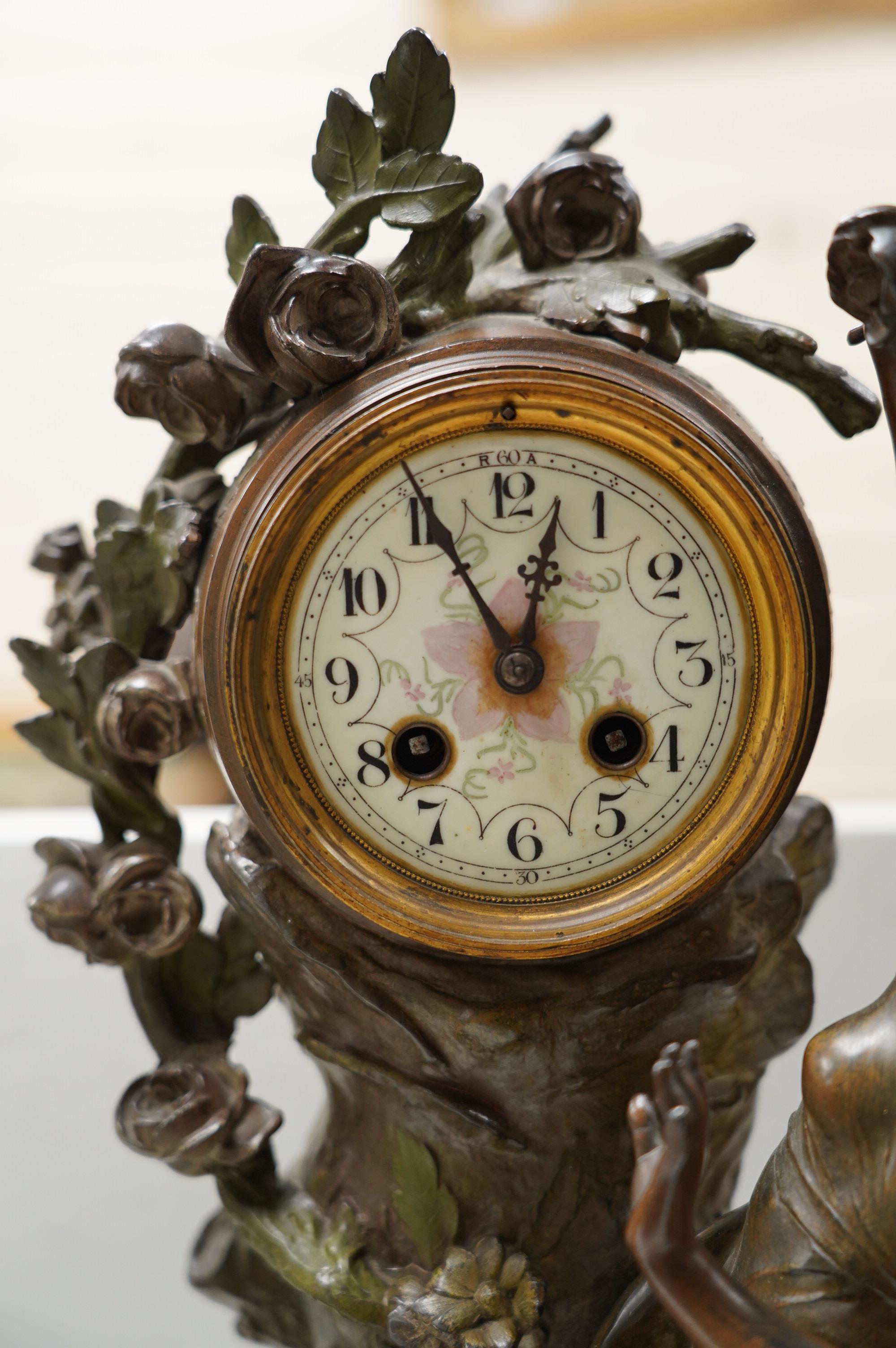 A French Art Nouveau spelter patinated figural table clock, ‘Jardin D’Amour’, with a late 19th century movement striking on a bell, height 53cm. Condition - good